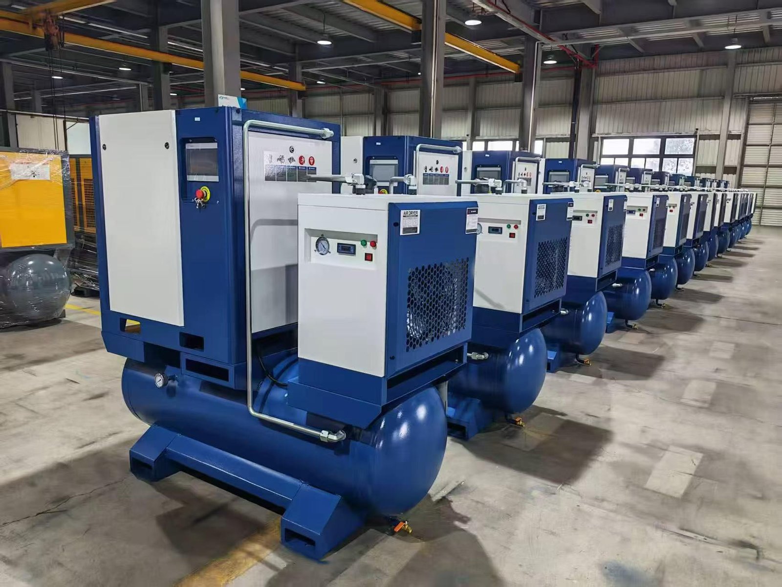 SAYI integrated screw air compressors with built-in air receivers lined up in the workshop before packing