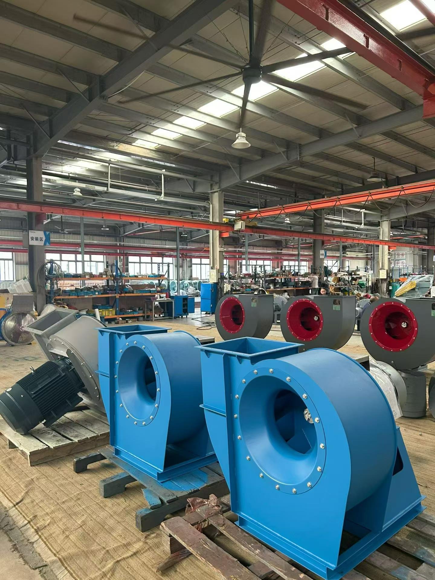 TMG industrial piston air compressors with vertical air receivers staged in the warehouse before shipment to the fair
